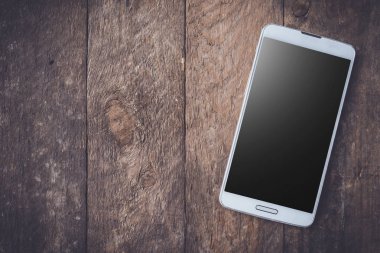 Ahşap masa modern beyaz akıllı telefon.