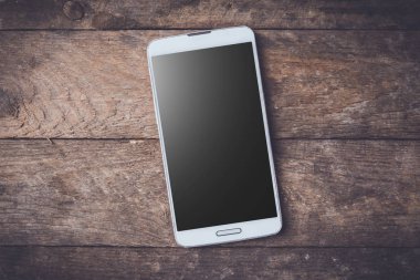 Ahşap masa modern beyaz akıllı telefon.
