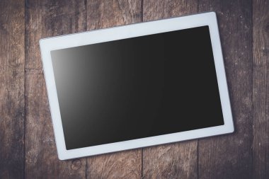 Modern beyaz dijital tablet ahşap masa üzerinde.