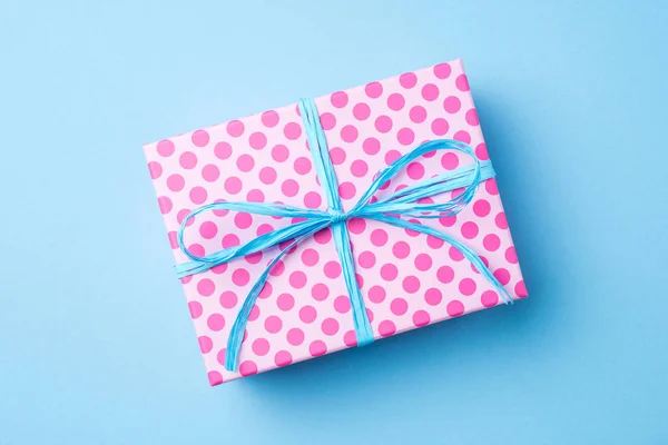Pink dotted gift box on blue background — Stock Photo, Image