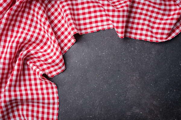 Red folded tablecloth on gray stone table