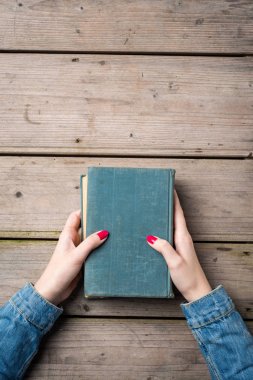 Ahşap masa üzerinde kitap holding kadının eller