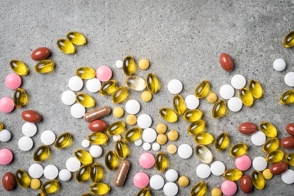 Красочные таблетки на сером каменном столе — стоковое фото