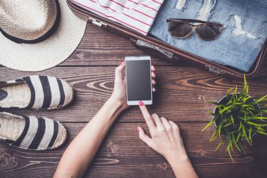 Seyahat hazırlıkları kavramı açık bavul, giysi ve aksesuarları ile ahşap tablo