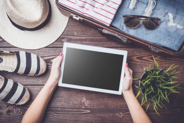 Seyahat hazırlıkları kavramı açık bavul, giysi ve aksesuarları ile ahşap tablo