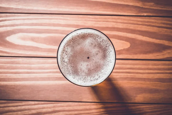 Vista aérea de vaso de cerveza sobre mesa de madera . — Foto de Stock