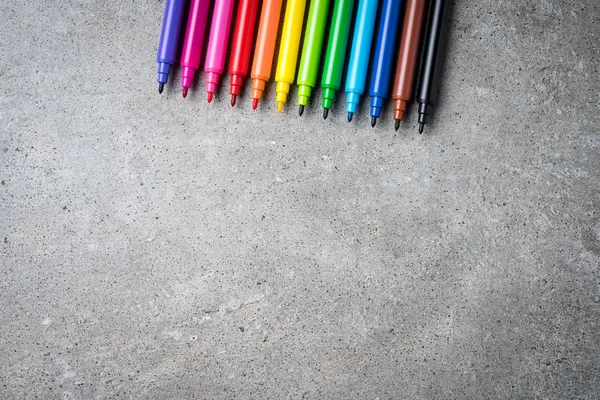 Overhead shot of colorful markers on gray stone table. — Stock Photo, Image