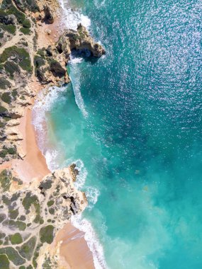Kumlu plaj ve okyanus güzel açık turkuaz su ile havadan görünümü.