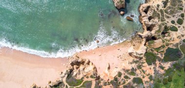 Kumlu plaj ve okyanus güzel açık turkuaz su ile havadan görünümü.