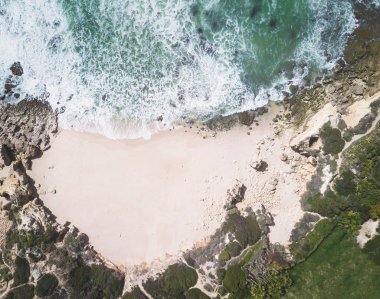 Kumlu plaj ve okyanus güzel açık turkuaz su ile havadan görünümü.