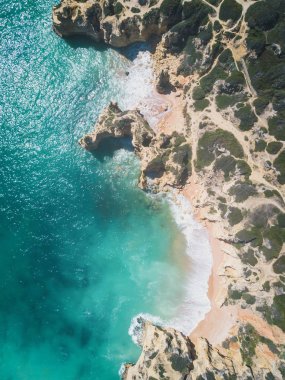 Kumlu plaj ve okyanus güzel açık turkuaz su ile havadan görünümü.