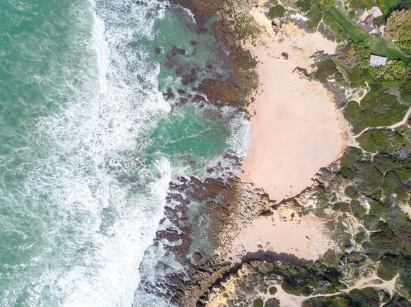 Kumlu plaj ve okyanus güzel açık turkuaz su ile havadan görünümü.