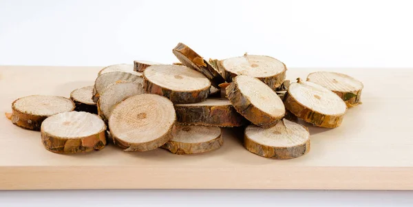 Купка маленьких круглих шматків розпиляних гілок сосни на дерев'яному плані — стокове фото