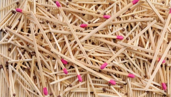 Many matches with brown and rose match heads scattering on rows — Stock Photo, Image