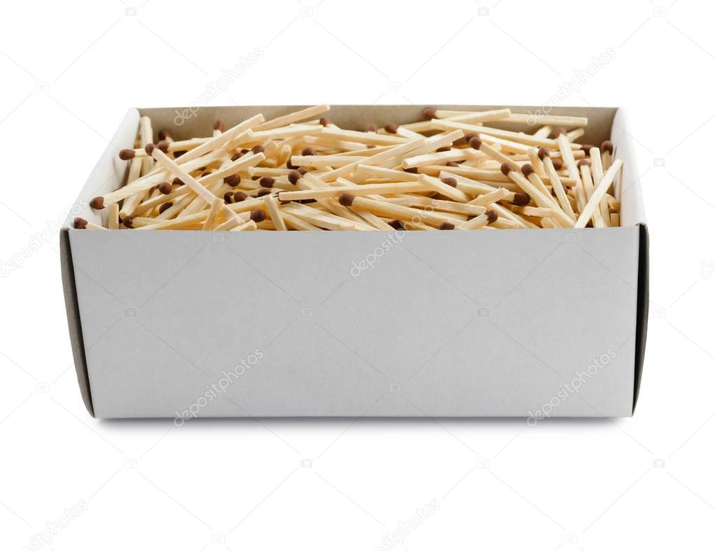 Big open cardboard box filled with matches on white background