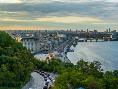 Gün batımında yaya köprüsünden Kyiv 'in Podil ilçesine bakın.