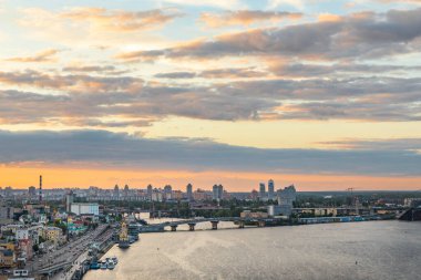 Gün batımında yaya köprüsünden Kyiv 'in Podil ilçesine bakın.
