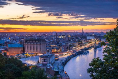 Gün batımında yaya köprüsünden Kyiv 'in Podil ilçesine bakın.