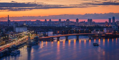Gün batımında yaya köprüsünden Kyiv 'in Podil ilçesine bakın.