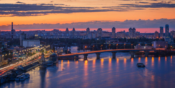 View to Podil district of Kyiv city from the Pedestrian Bridge at sunset.