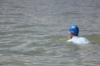 Mavi bir şapka ve gözlük nehirde Yüzme genç adam   