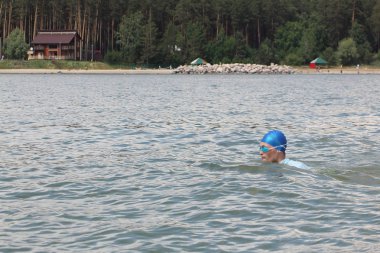 Mavi bir şapka ve gözlük nehirde Yüzme genç adam   