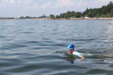 Mavi bir şapka ve gözlük nehirde Yüzme genç adam   