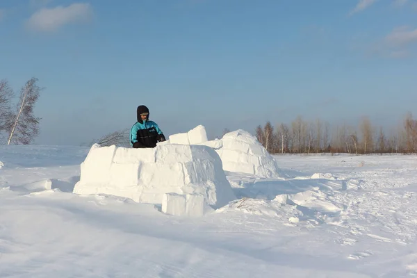 Homem construindo um iglu de blocos de neve em uma clareira no inverno — Fotografia de Stock
