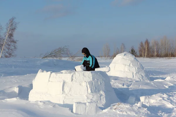 Homme construisant un igloo de blocs de neige sur une clairière en hiver — Photo