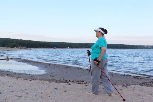 Nordic Walking - yaşlı kadın akşam nehir boyunca hiking