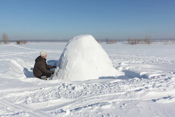 El hombre construyendo un iglú de bloques de nieve en un claro en el invierno —  Fotos de Stock