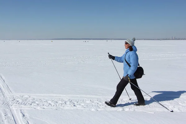 Nordic Walking - Dorosła Kobieta w Błękitnej Kurtki turystyczne na śniegu — Zdjęcie stockowe