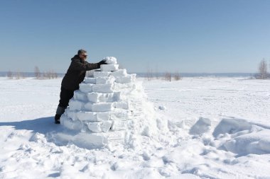 Kışın bir Eskimo bir glade üzerinde bina adam