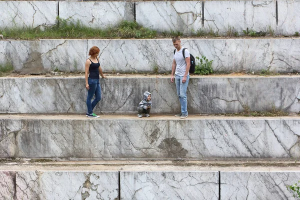 Man, vrouw en het kind reizen rond een marmeren put in de su — Stockfoto