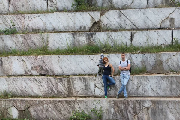 El hombre, la mujer y el niño viajando alrededor de un pozo de mármol en el su —  Fotos de Stock