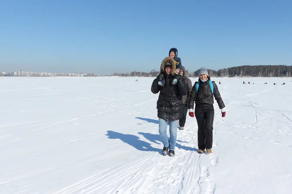 Glückliche Familie, die im Winter im Schnee unterwegs ist — Stockfoto