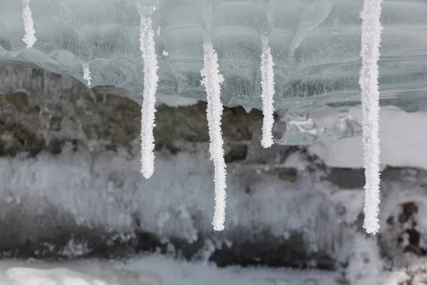 Ijspegels in hoar-vorst op het ijs van een bevroren rivier — Stockfoto