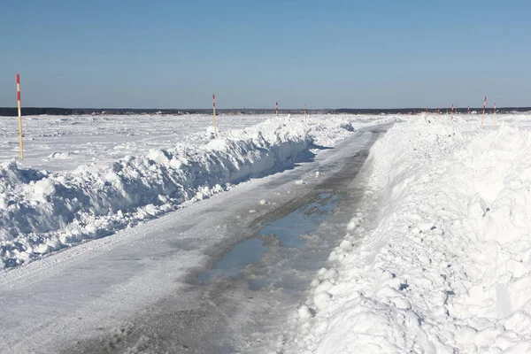 Ice road melting on a frozen reservoir in winter — Stock Photo, Image