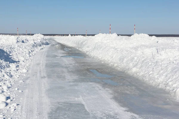 Ice road melting on a frozen reservoir in winter — Stock Photo, Image