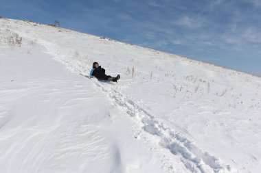 Bir plastik kızak ile bir dağ tırmanma siyah ceketli adamı 
