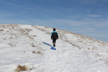 Bir plastik kızak ile bir dağ tırmanma siyah ceketli adamı 