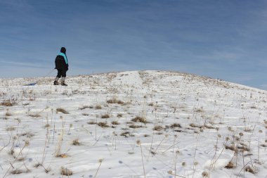 Bir plastik kızak ile bir dağ tırmanma siyah ceketli adamı 