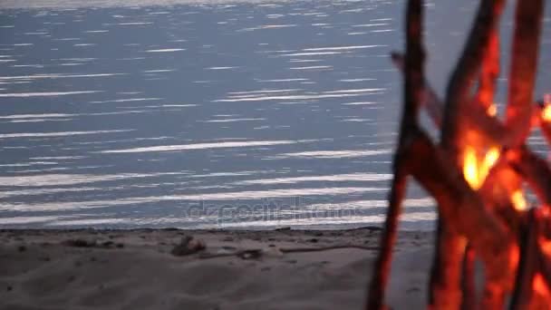 Вода в реке на закате на фоне пожара — стоковое видео