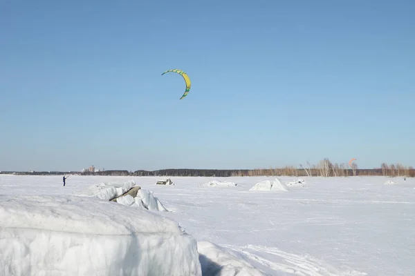 Man is op de Ski's op de bevroren rivier vliegeren in de winter — Stockfoto