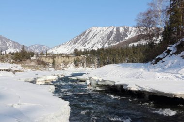 Buz sahil yakınındaki dağların arasında erime nehir su akışı