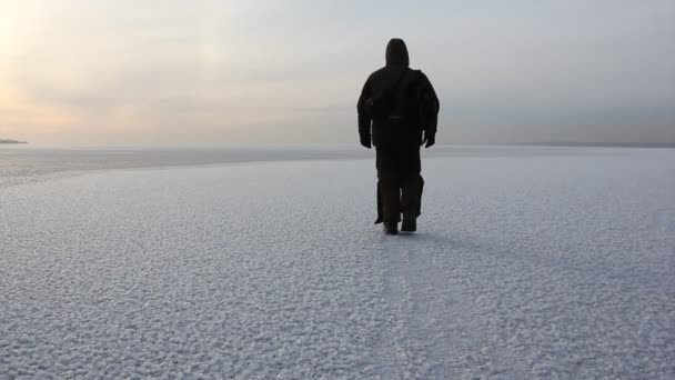 Az ember a meleg ruhát, séta a fagyasztott river, a naplemente, Ob tartály, Szibéria, Oroszország — Stock videók