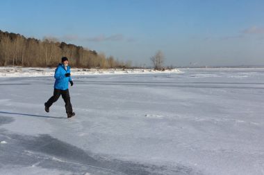 Donmuş bir nehir, O buz üzerinde çalışan bir mavi ceketli adamı