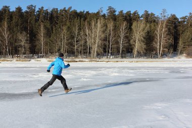 Donmuş bir nehir, O buz üzerinde çalışan bir mavi ceketli adamı
