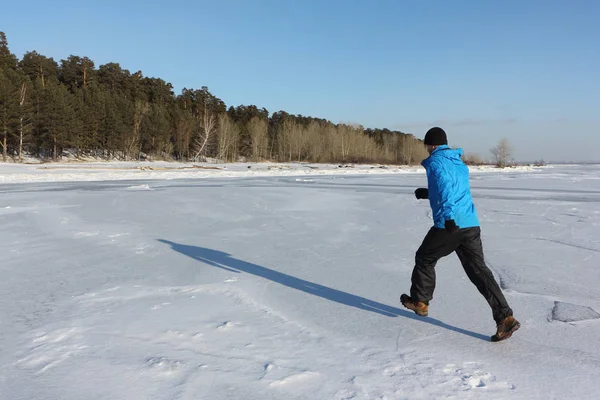 Człowiek w Błękitnej Kurtki, uruchomiona w lodzie na zamarzniętej rzece, — Zdjęcie stockowe