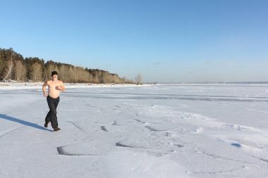 Adam bir nehir buz çalışan çıplak bir gövde ile bir kap içinde